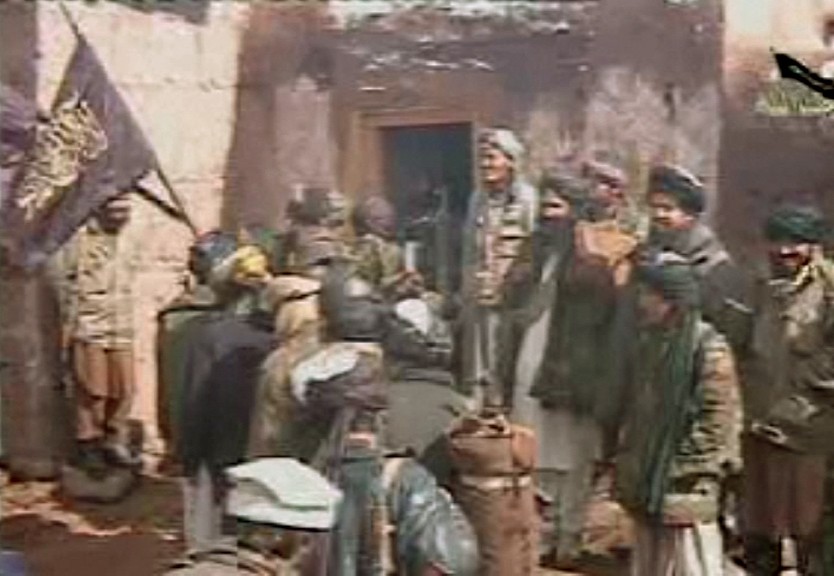 Yuldash addresses a group of followers, second from right