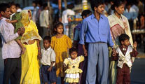 Indian family in brightly-coloured clothing standing on a busy roadside