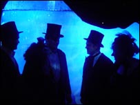 Ghostly figures wander by a wall of ice