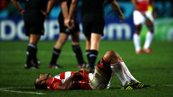 A Japan rugby player lies prostrate