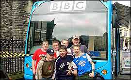 children pose in front of the blue bus next to Cardiff castle