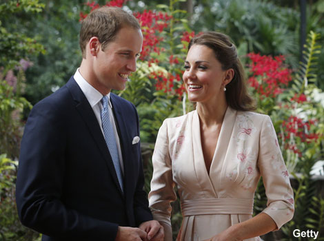 The Duke and Duchess of Cambridge smile as they look at an orchid. 