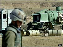 Şüpheli variller çevresinde inceleme yapan bir asker