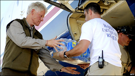 Former US President Bill Clinton helps unload bottled water from a plane at Port-au-Prince airport, Haiti, 18 January 2010