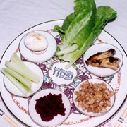 Plate with seder meal: lettuce, lamb bone, charoset, horseradish paste, celery and roast egg