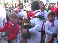 Children and adults beat out the May Day Song