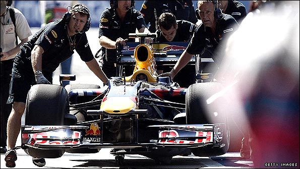 Red Bull engineers push Sebastian Vettel's stricken car back to the garage in Valencia