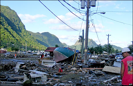 A resident walks past debris in a playground and a tennis park left by the tsuami that struck early Tuesday Sept. 29, 2009 in Pago Pago, American Samoa