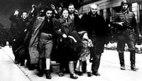 Jewish civilians are marched down the street during the destruction of the Warsaw Ghetto. The Bermuda Conference began on the same day the Germans made their final assault on the ghetto
