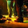 Low-level view of stage with cables, mic stands and performers' feet
