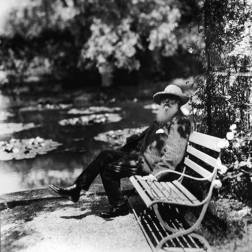 French impressionist painter Claude Monet sits on a bench beside the water lily pond at Giverny in France in 1910.