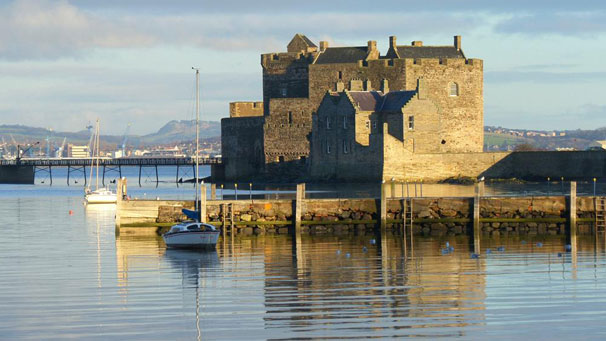 A view of Blackness Castle, surrounded by still waters in the bright, winter sun.