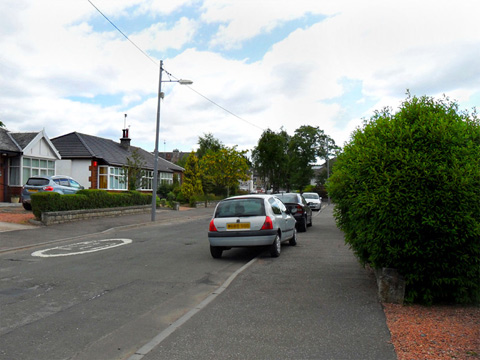 A wide suburban street, lined with 1930s-style bungalows.