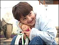 Arta Gjini hugging a doll