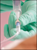 hand squeezes medical tube