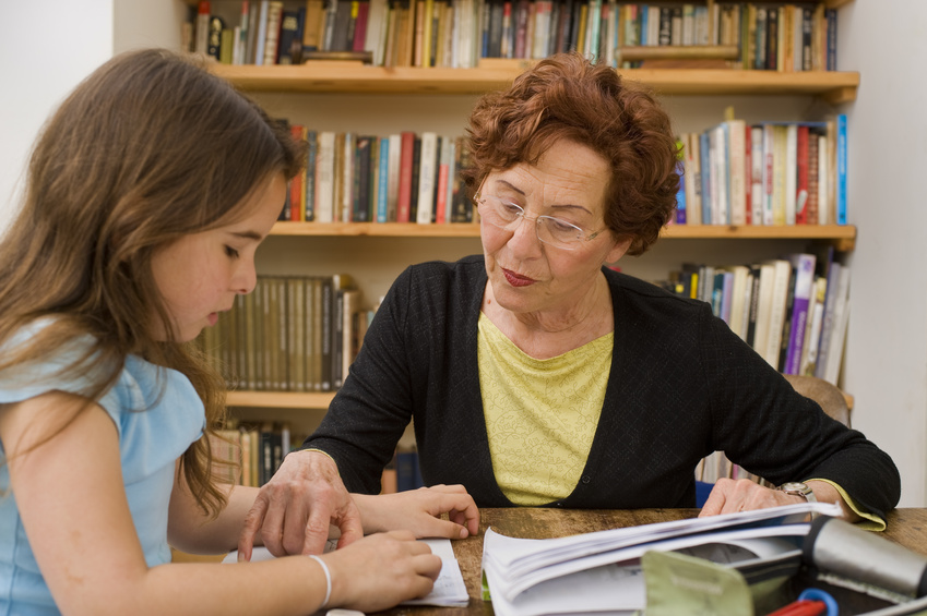 senior helping child doing homework @ Noam - fotolia