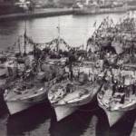 This picture was taken by me from the top of the water tower at Great Yarmouth. it shows the 63rd Motor Torpedo Boat flotilla dressed to celebrate VE Day. MTB 753 is the boat tied up alongside the jetty, with some of my shipmates on the fo'c'sle.