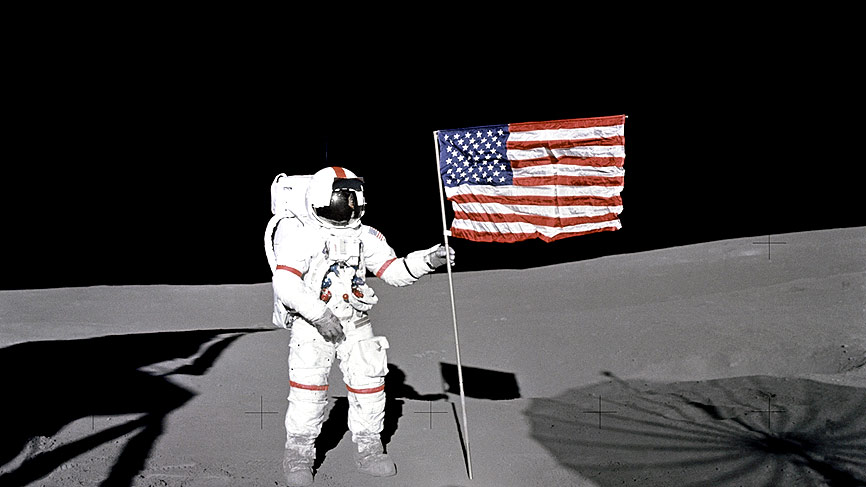 Astronaut Alan B. Shepard Jr., Apollo 14 Commander, stands by the U.S. flag on the lunar Fra Mauro Highlands