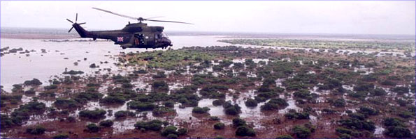Helicopter carrying British aid across flood water in Mozambique in March 2001