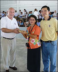 Musical Director Mike Booty of the South Norfolk Youth Symphonic Band presenting recorders and books to school in Ban Naam Kem, Thailand