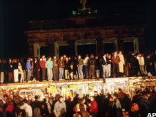 People standing on and around the Berlin Wall in November 1989