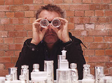 Photo: Damien Hirst photographed in London in 2003 with two glass rooks over his eyes in front of his 2003 set Mental Escapology, The RS&A Contemporary Artists Chess Set Collection