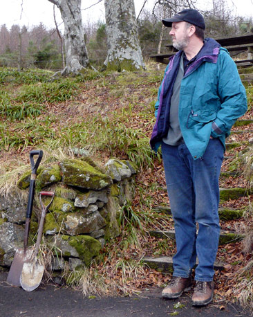 Man standing beside two spades