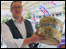 Man holding a whole cheese