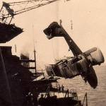 HMS Kent's Walrus spotter plane being winched aboard