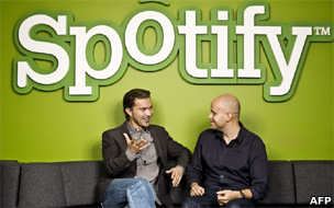 founders Martin Lorentzon (L) and Daniel Ek talking in front of a giant Spotify logo