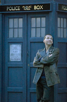 The Ninth Doctor Christopher Ecclestone standing outside a TARDIS