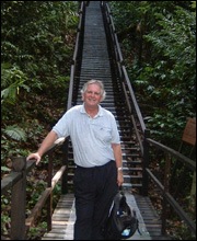 Richard Collinson standing at the foot of a Bridge in the Brunei Rainforest