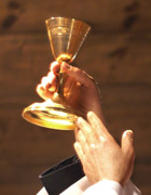 Priest's hand holding chalice at communion