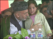 حامد کرزی، يک کودک هزاره را در آغوش گرفته است