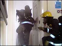 Firefighters entering a smokefilled room
