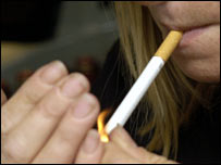 زنی سيگار آتش می زند - عکس از آرشيو