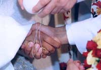 A cord is tied around the bride and groom's hands