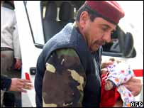  ایک عراقی فوجی ایک زخمی بچے کو ہسپتال لے جاتا ہوا 
