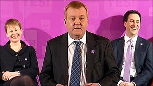 Ed Charles Kennedy, watched by Caroline Lucas and Ed Miliband at the event