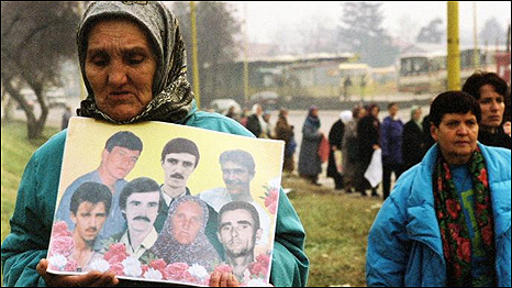 A Long Search: a Serb woman, holding pictures of the male members of her family killed in the massacre at Srebenica