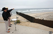 Mexican musicians look over the border fence into the USA