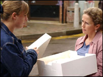 One woman looking inside another's box