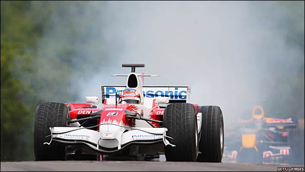 Timo Glock smokes the tyres on his Toyota, almost obscuring the Red Bull of Mark Webber behind