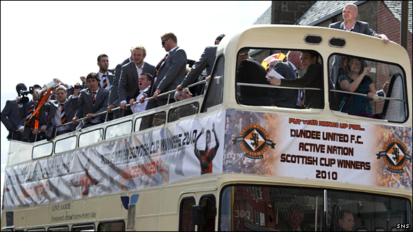 Dundee United players and coaching staff celebrate their Scottish Cup final victory aboard the open top bus