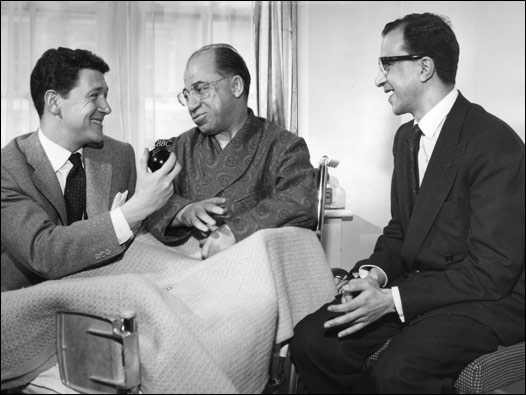 BBC Türkçe'den Yavuz Karaözbek, milletvekili Emin Kalafat ile mülakat yapıyor. Dönemin Türk basın ateşe yardımcısı İlhan Çevik ise sağda. BBC Türkçe o günlerde, kısa süre önce İngiltere'de düşen Türk uçağı ile ilgili olarak mülakatlar yapıyor, hayatta kalanların mesajlarını aktarıyordu. 17 Şubat 1959'da dönemin başbakanı Adnan Menderes'in de içinde bulunduğu ve İngiltere'ye gelmekte olan THY uçağı, Londra'da düşmüştü. Türk delegasyonu Kıbrıs Cumhuriyeti'ni kuracak Londra Antlaşması için yola çıkmıştı. 04/04/1959 © BBC