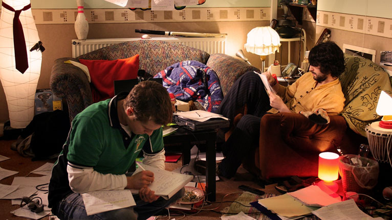 James Kristian (Tom) and Gareth Aldon (Steve) writing essays in a scene from the comedy.