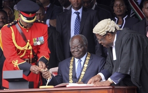 Kenyan President Mwai Kibaki prepares to sign the new constitution into law. (AP Photo/Khalil Senosi)