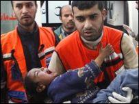 Gazze'deki İsrail saldırılarında yaralanan bir çocuğu taşıyan sağlık görevlileri