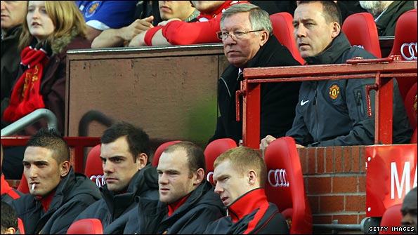 Wayne Rooney sits on the Old Trafford bench as Sir AlexFerguson watches ther action