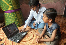 A man and a boy looking at the computer